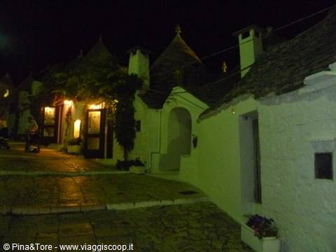 Night in Alberobello's trulli, whitewashed stone houses with conical roofs lit up