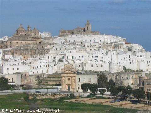 Ostuni, the white city: lime-washed houses clustered on the hill under blue sky