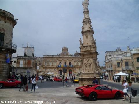 Ostuni square with Sant'Oronzo column and red sports cars