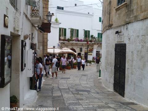 Tourists stroll among whitewashed houses and stone alleys in Locorotondo