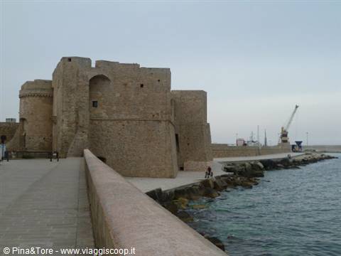 Swabian castle of Monopoli by the pier, fisherman on the rocks