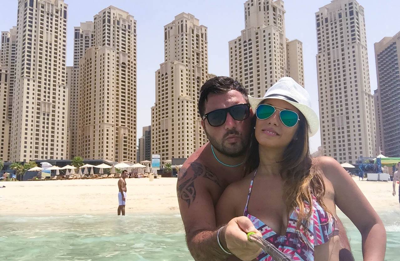 Coppia in spiaggia davanti ai grattacieli di Dubai Marina