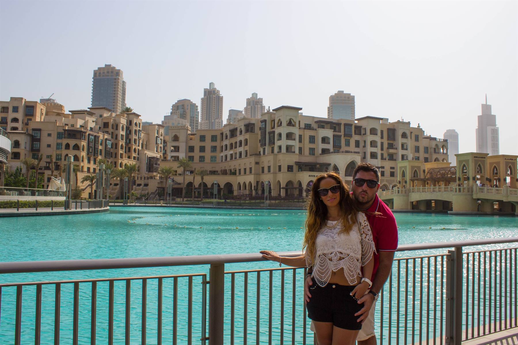 Coppia appoggiata alla ringhiera davanti al lago turchese di Burj Khalifa Lake, Dubai