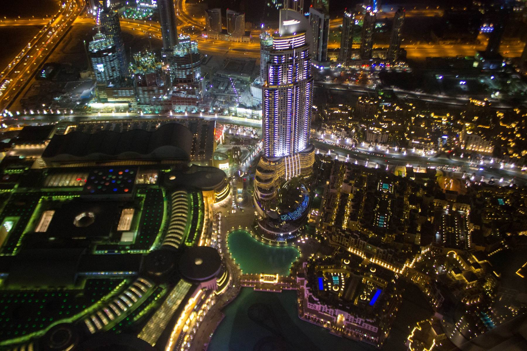 Grattacieli illuminati di Downtown Dubai visti dall'alto di notte, con il lago artificiale