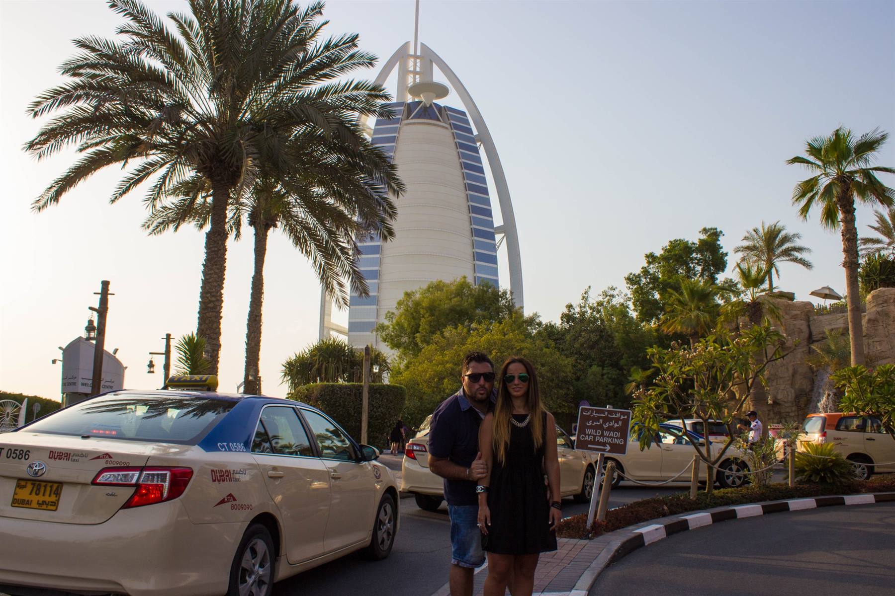 Coppia in posa accanto a un taxi davanti al Burj Al Arab, Dubai