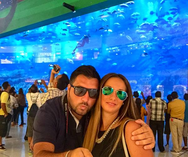 Couple in sunglasses posing before the huge Dubai Mall aquarium tank