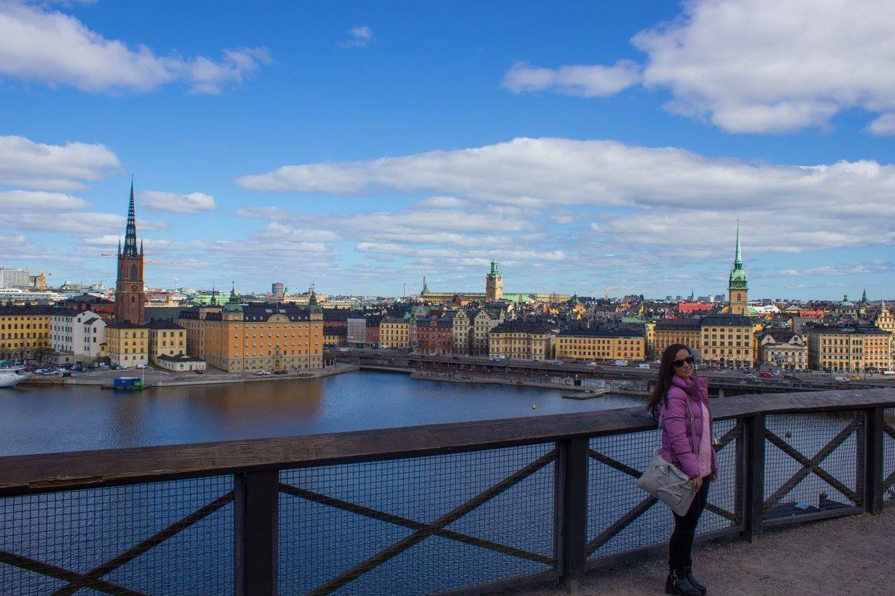 Donna con piumino rosa accanto alla cancellata, Riddarholmen e Gamla Stan a Stoccolma