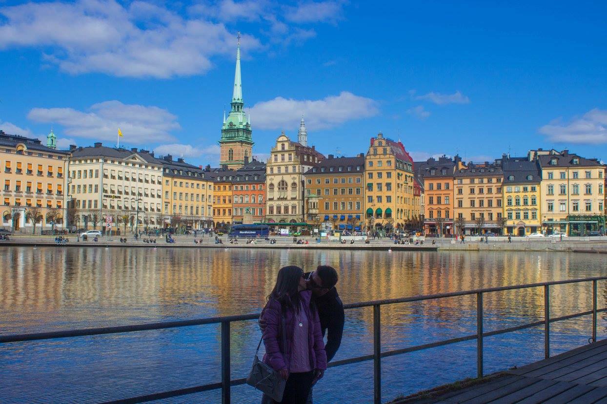 Coppia baciata lungo la banchina davanti alle case colorate di Gamla Stan, Stoccolma