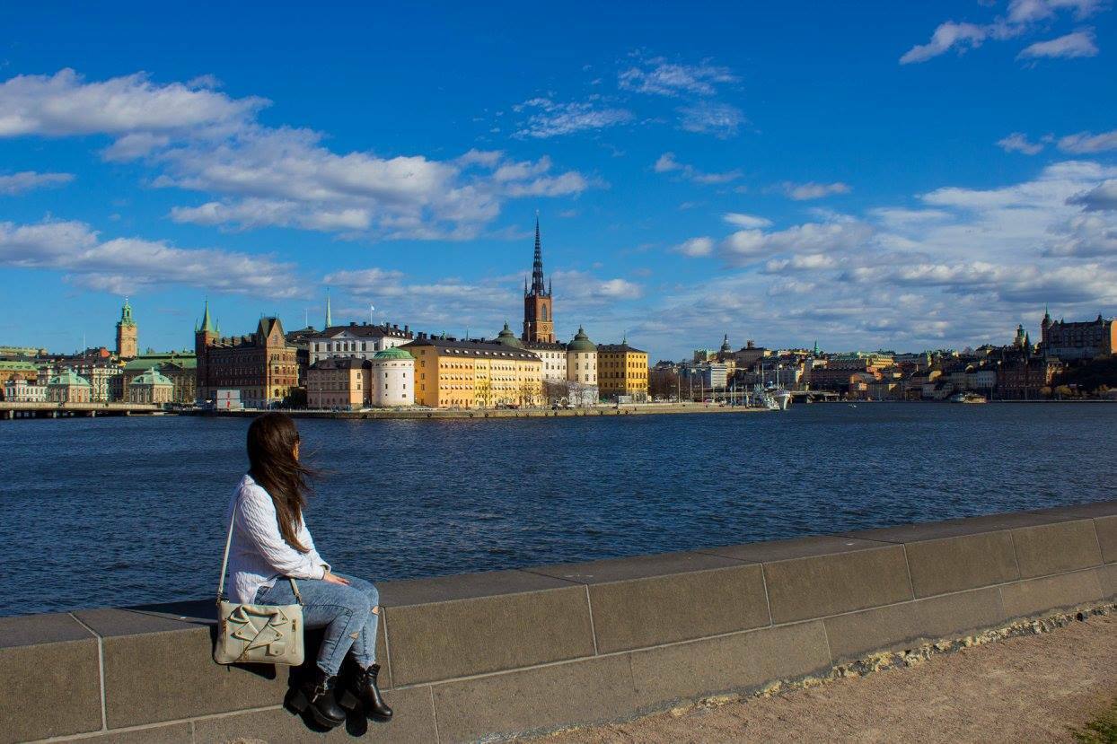 Ragazza seduta sul muretto di granito davanti a Riddarholmen, Stoccolma
