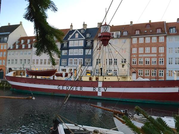 Lightship Gedser Rev moored at Nyhavn in front of colorful Copenhagen townhouses