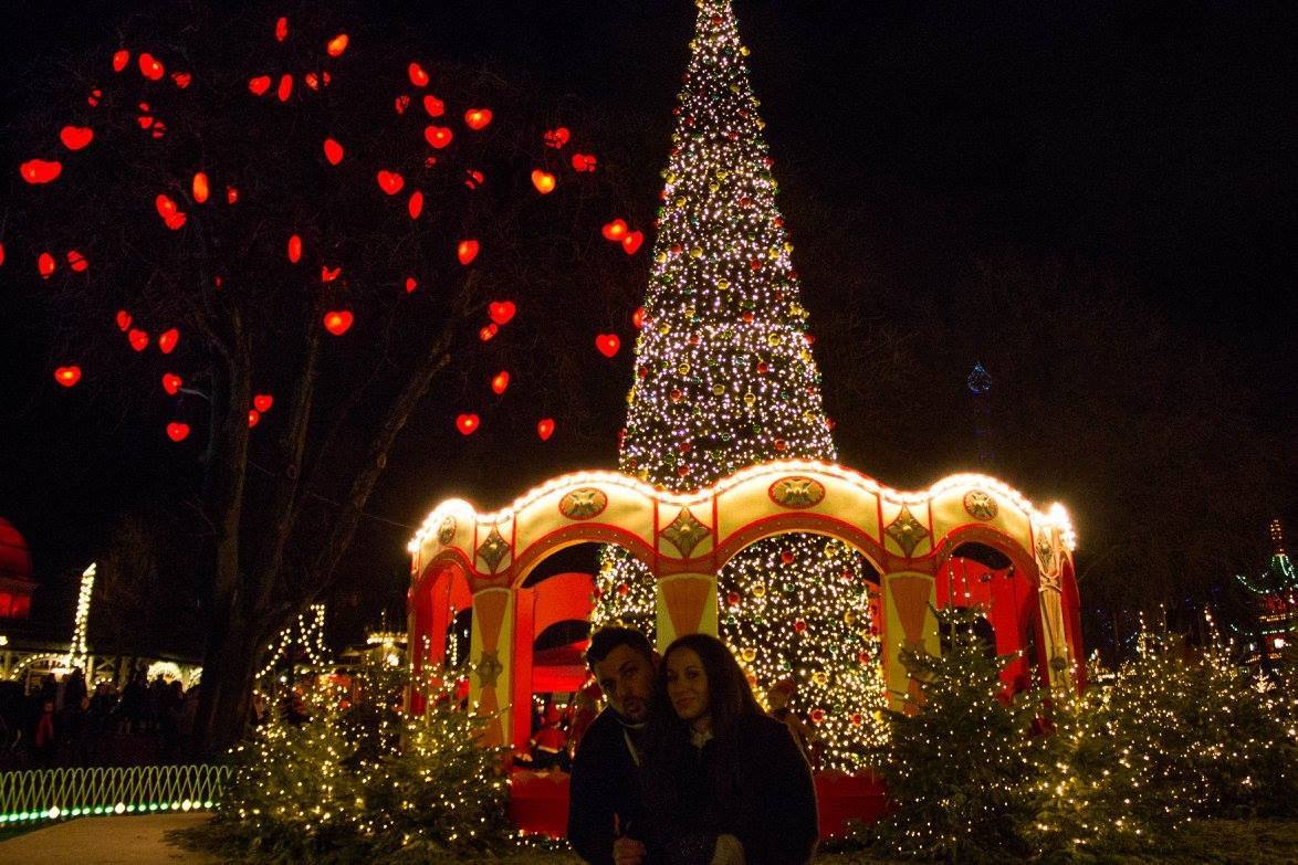 Coppia davanti all'albero di Natale illuminato ai Giardini Tivoli, Copenhagen