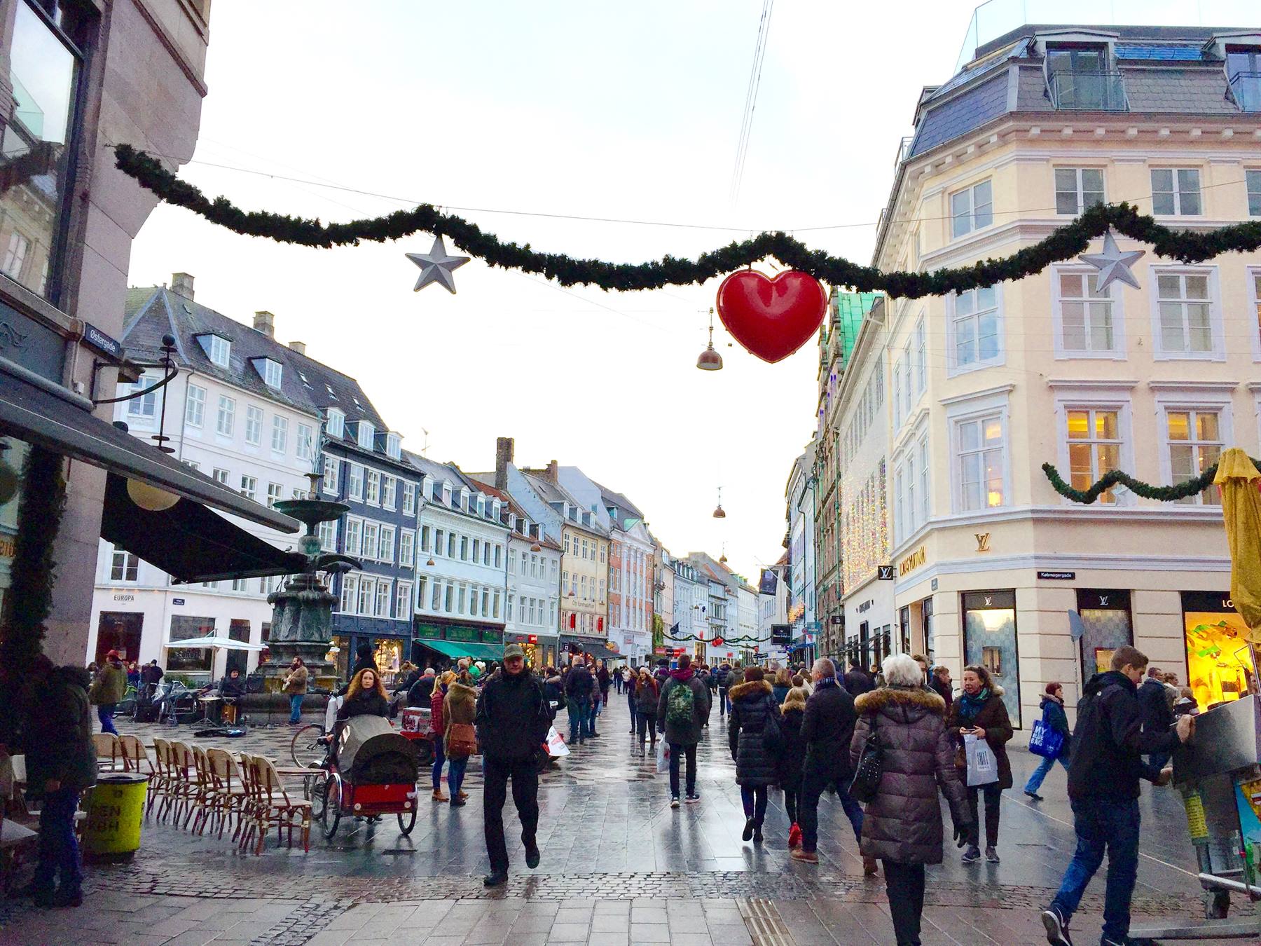 Pedone sotto ghirlande natalizie con cuore rosso a Stroget, Copenaghen