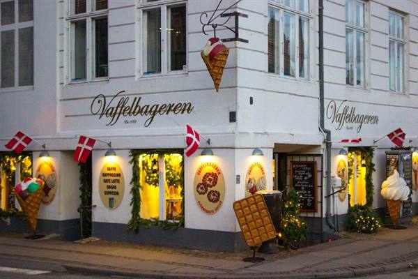 Vaffelbageren's lit shop window with Danish flags and decorative ice cream cones
