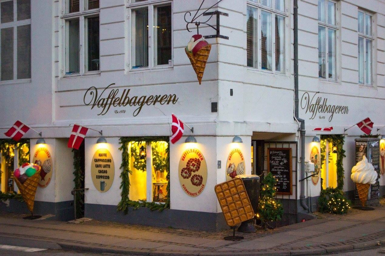 La vetrina illuminata de Vaffelbageren con bandiere danesi e coni decorativi