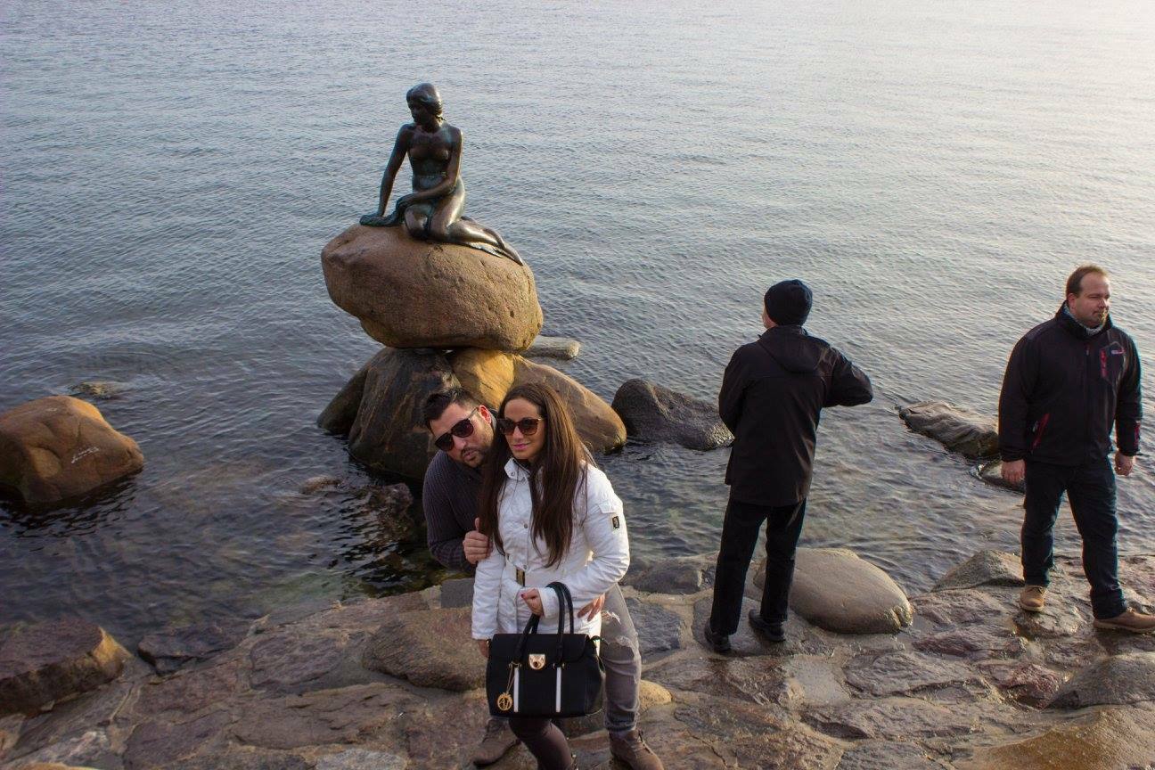 Turisti davanti alla Sirenetta di Copenaghen, bronzo su roccia tra le acque