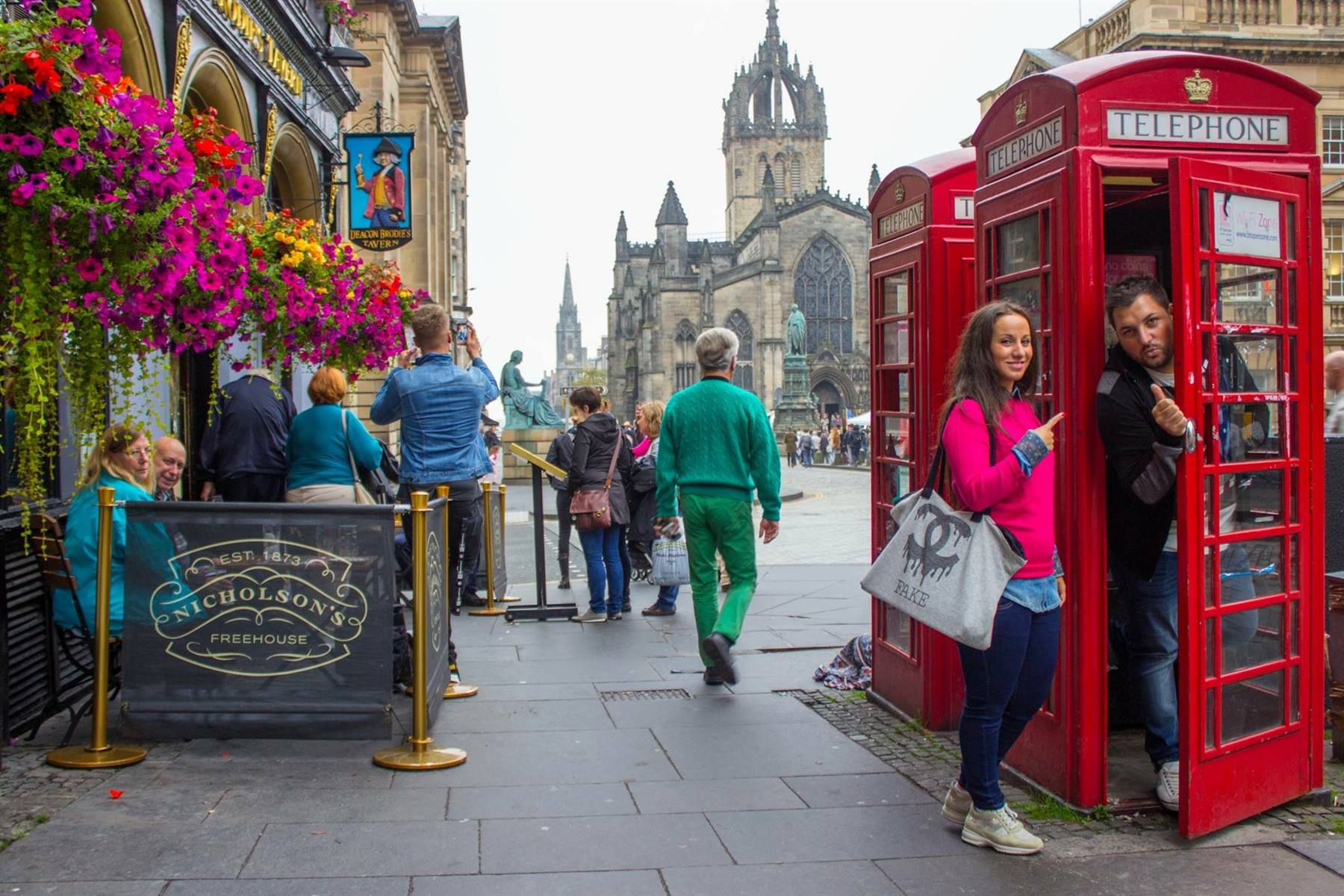 Turisti in cabine telefoniche rosse sulla Royal Mile a Edimburgo