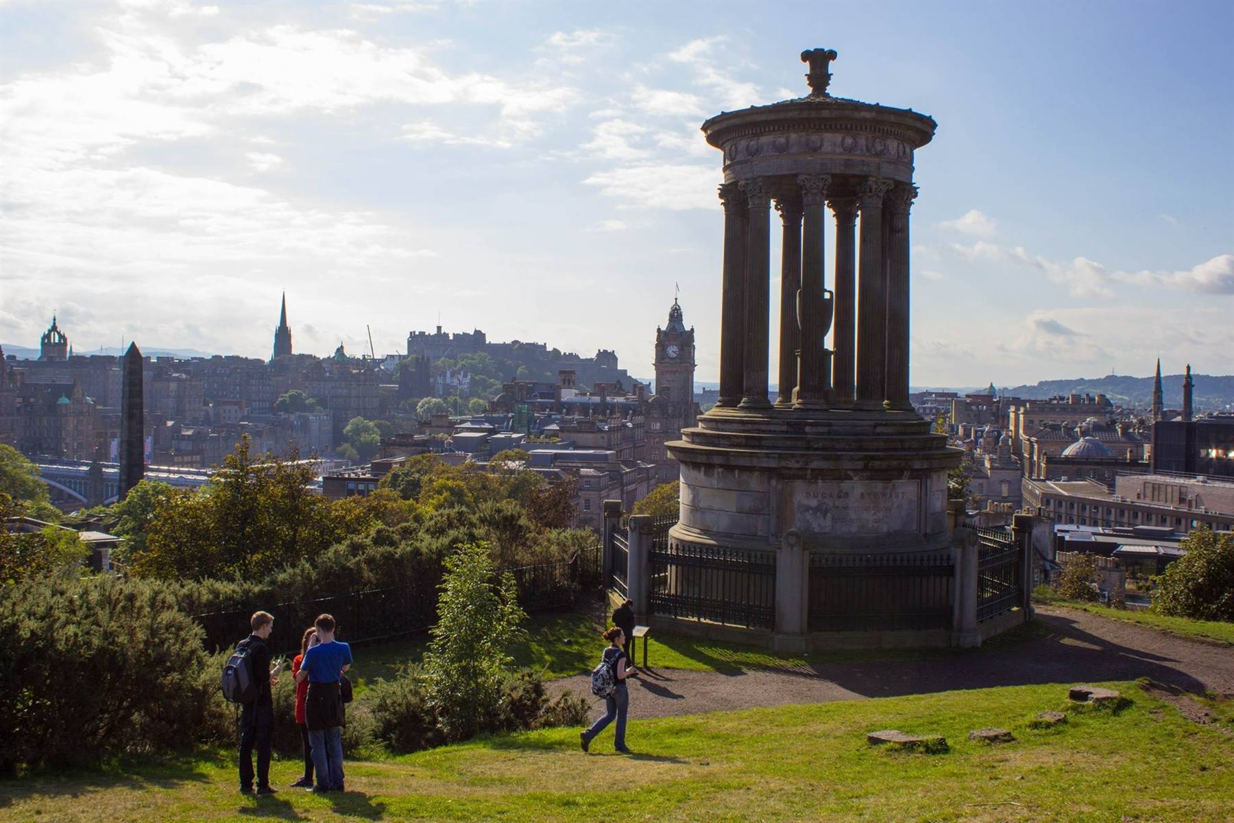 Turisti sul prato accanto al Monumento Dugald Stewart, Calton Hill, Edimburgo