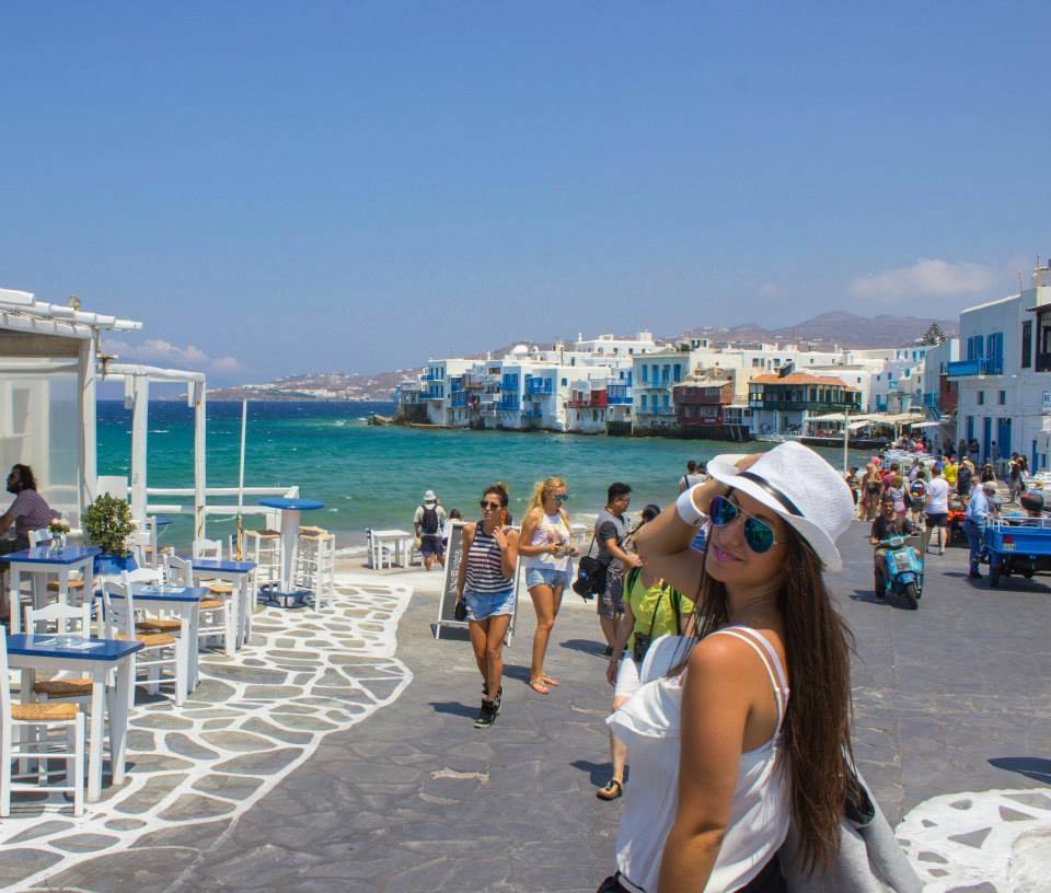 Turista con cappello bianco sul lungomare di Little Venice, Mykonos