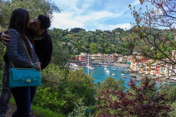 Couple kissing among trees above the harbor of Portofino