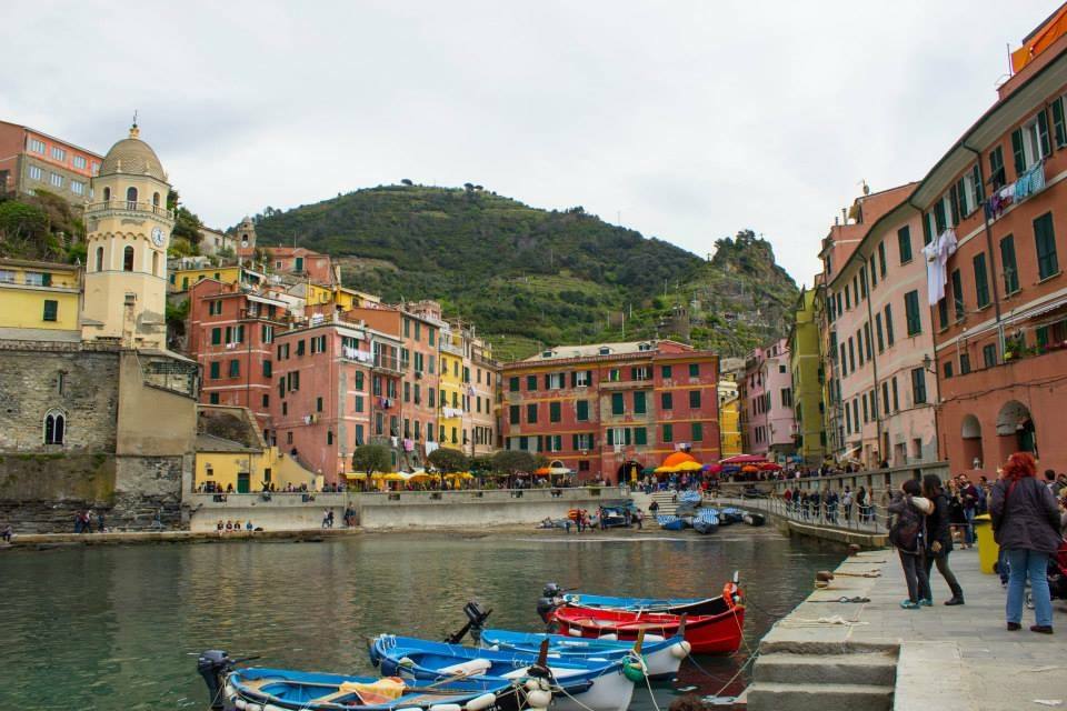 Vernazza: barche colorate nel porto, case pastello e turisti sulla banchina