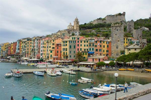 Portovenere: colorful boats in the harbor, waterfront houses, castle on the hill