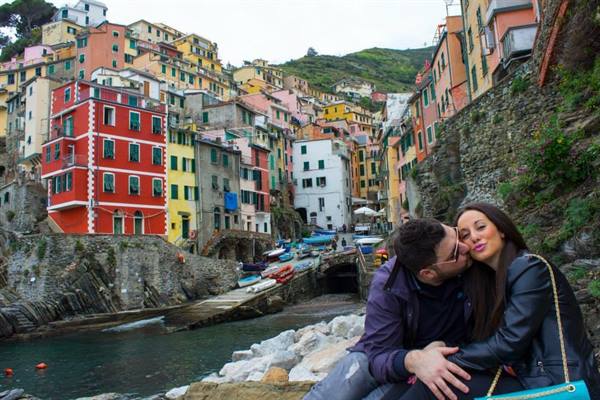 Riomaggiore, Cinque Terre: couple hugging in front of colorful houses by the stream