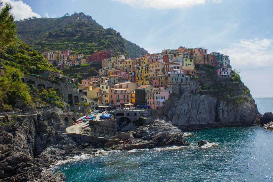 Case colorate di Manarola sulle scogliere sopra il mare con barche