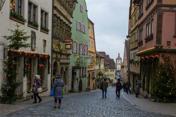 Cobbled street in Rothenburg with half-timbered houses, Christmas decorations and pedestrians