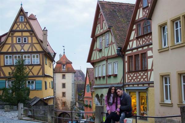 Couple sitting among colorful half-timbered houses in Rothenburg ob der Tauber