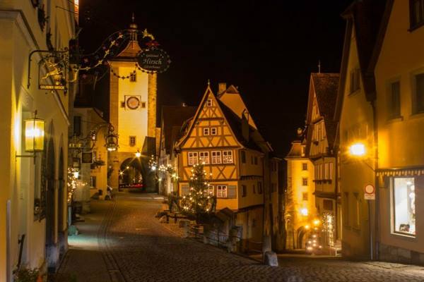Illuminated signs and half-timbered houses on Rothenburg's night street