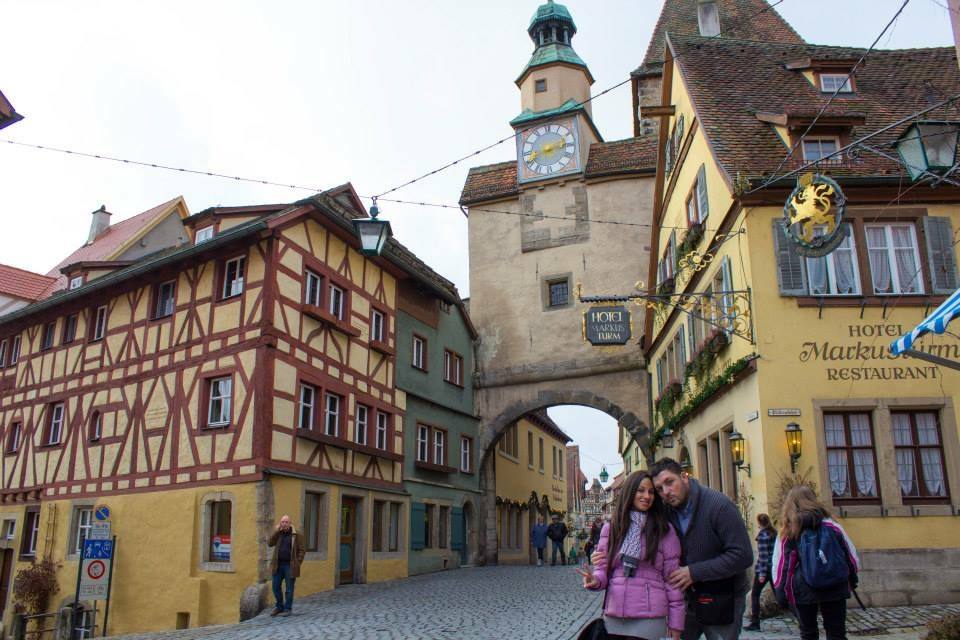 Turisti si abbracciano davanti al Markusturm tra case a graticcio a Rothenburg