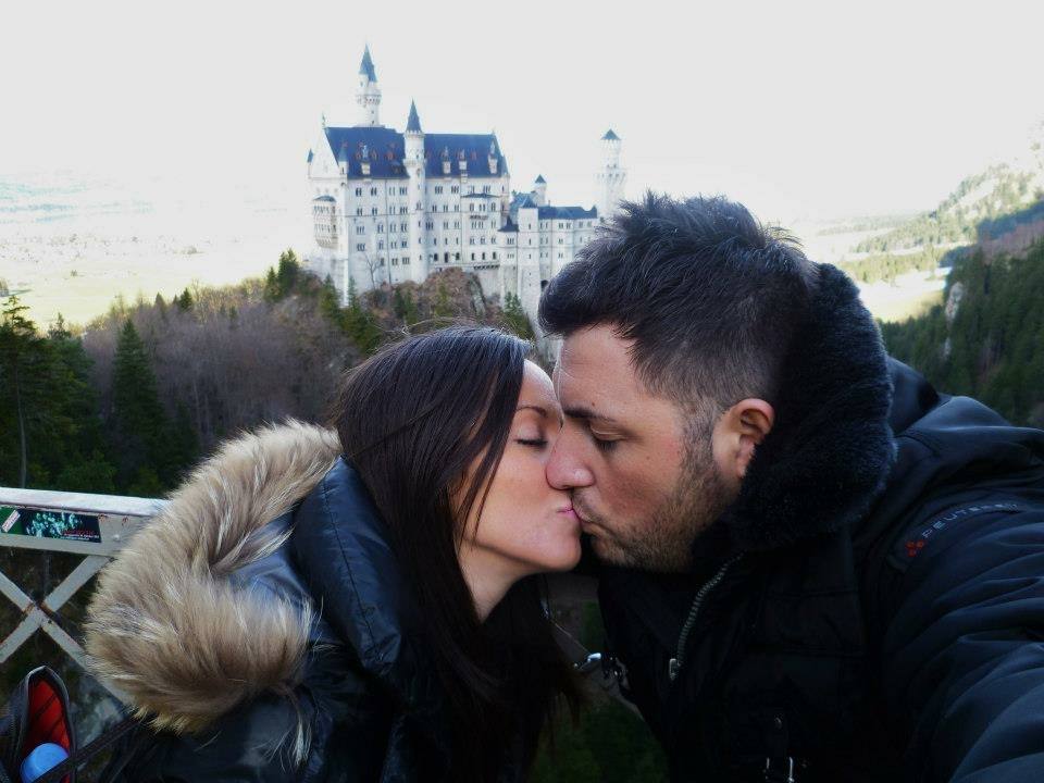 Coppia che si bacia davanti al castello di Neuschwanstein, inverno