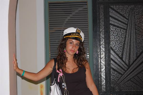 Girl in captain hat from Zakynthos beside ornate wrought iron door