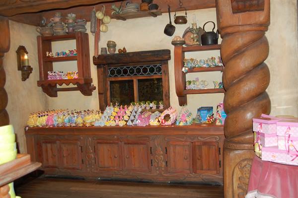 Colorful figurines on carved wooden sideboards beside a spiral column