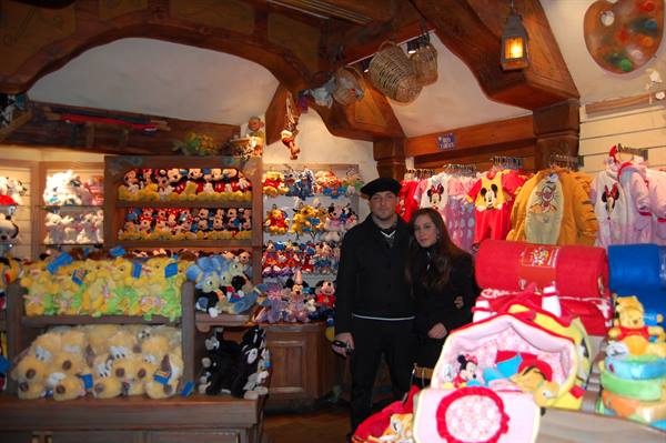 Couple among Mickey plush toys in a wooden Disney shop