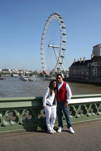 Couple on Westminster Bridge with the London Eye and Thames behind