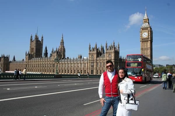 Couple on Westminster Bridge, Big Ben and red bus behind them