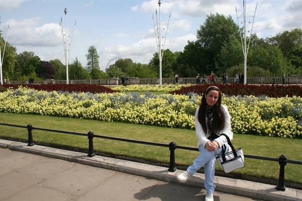 Girl posing in front of flowerbeds in a London park