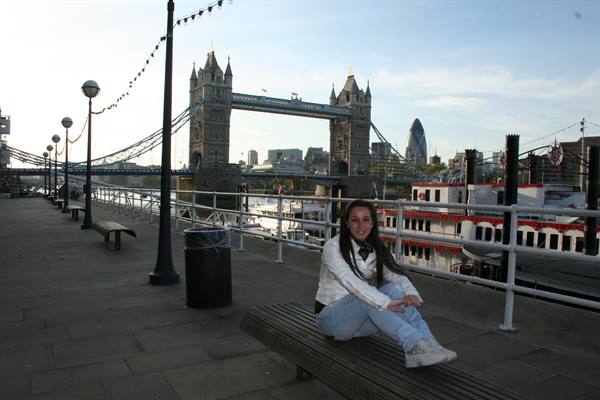 Girl sitting on a bench by the Thames, Tower Bridge behind