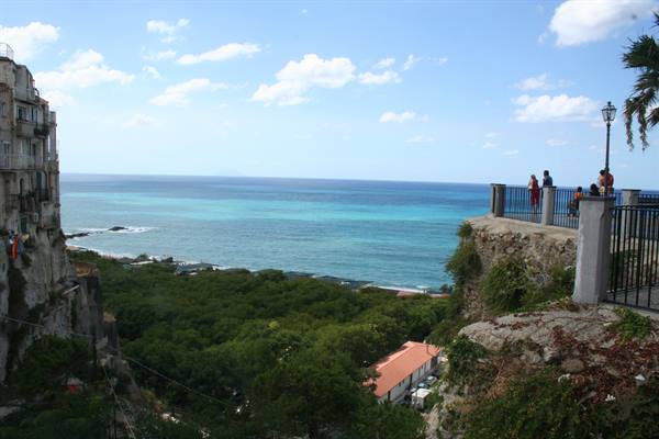 Tourists on Tropea's terrace gaze at the turquoise sea and cliffs