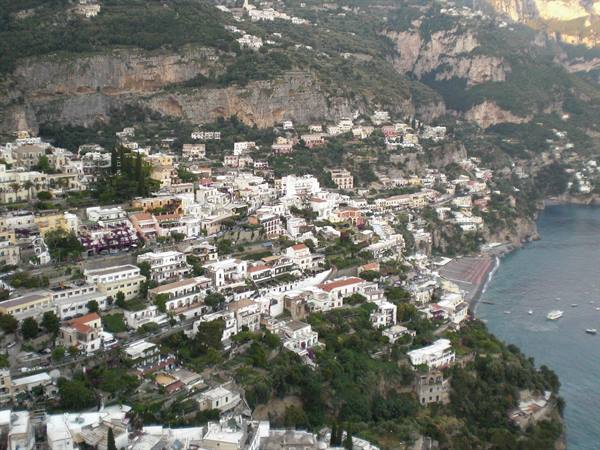 Positano's colorful houses tumble down to the sea among cliffs and greenery