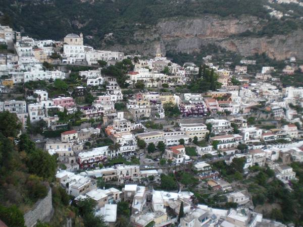 Positano's white houses cascade down the mountainside in soft evening light