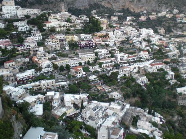 Positano's white houses cascade down the hillside among pines and terracotta roofs