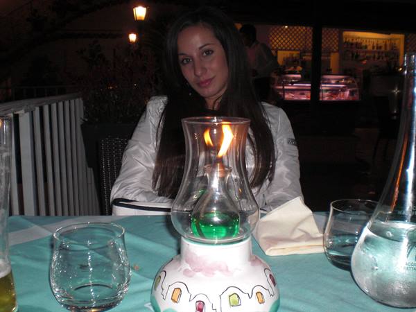 Woman at restaurant table with a hand-painted oil lamp