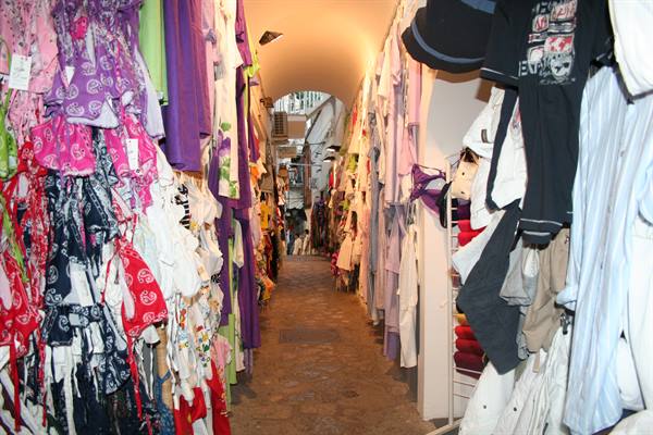 Narrow alley with colorful clothes hanging under an arch