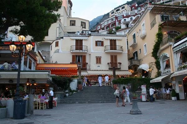 Tourists on a small square with steps among colorful Positano houses