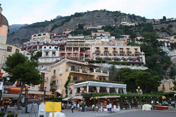 Positano's colorful houses on the cliff, tourists strolling in the square