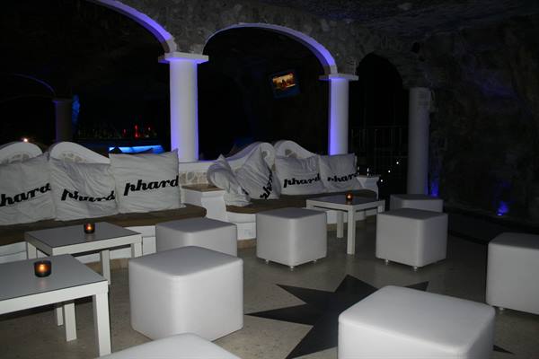 Cave lounge with white sofas and poufs, Phard cushions, blue lighting