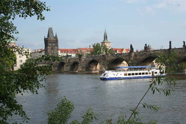 Boat on the Vltava in front of Charles Bridge with its bridge tower