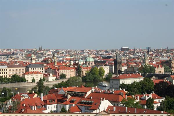 Red rooftops and domes of Prague along the Vltava river